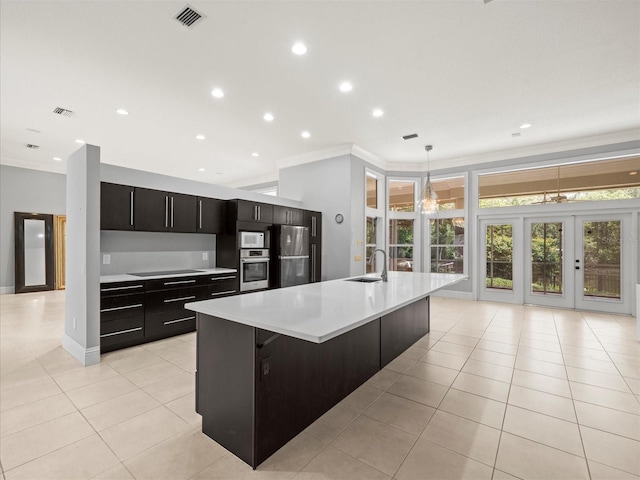 713 Argyle Pl, Temple Terrace, FL 33617 - kitchen with stainless steel appliances, dark cabinetry, light tile patterned floors, light countertops, and a spacious island