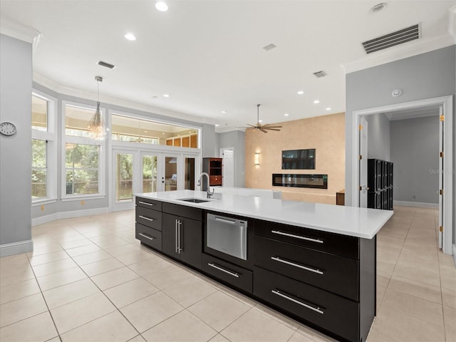 713 Argyle Pl, Temple Terrace, FL 33617 - kitchen featuring dark cabinetry, open floor plan, light countertops, light tile patterned floors, and ornamental molding
