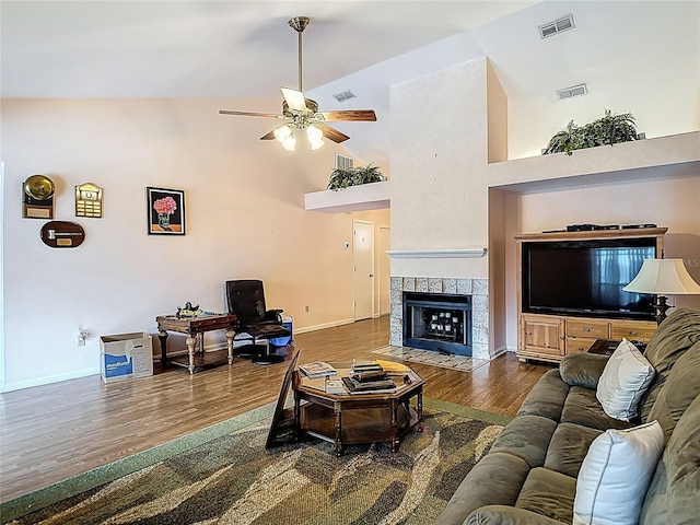 1906 White Cedar Way, Brandon, FL 33511 - living area featuring dark wood-type flooring, a ceiling fan, a tiled fireplace, and high vaulted ceiling