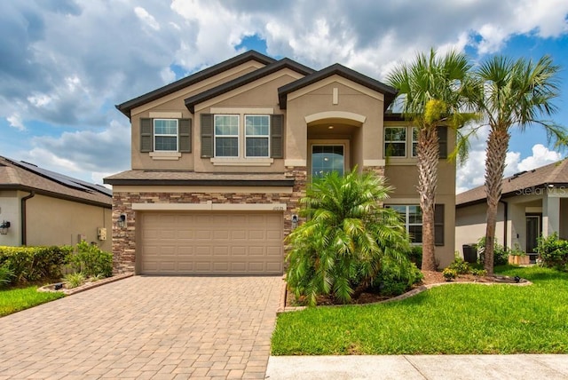 11035 Sage Canyon Dr, Riverview, FL 33578 - view of front facade featuring stucco siding, stone siding, a garage, decorative driveway, and a front lawn