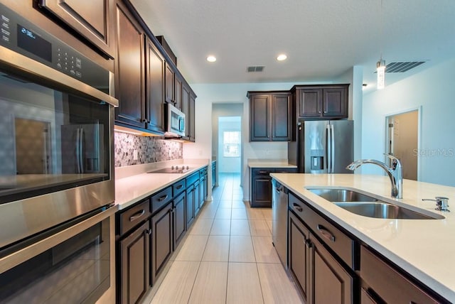 11035 Sage Canyon Dr, Riverview, FL 33578 - kitchen featuring appliances with stainless steel finishes, light countertops, backsplash, dark brown cabinetry, and recessed lighting