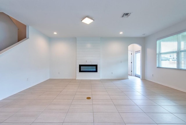 11035 Sage Canyon Dr, Riverview, FL 33578 - unfurnished living room with arched walkways, recessed lighting, light tile patterned floors, and a large fireplace