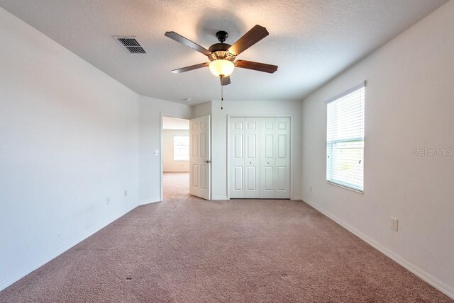 11035 Sage Canyon Dr, Riverview, FL 33578 - unfurnished bedroom with carpet, a closet, a textured ceiling, and ceiling fan