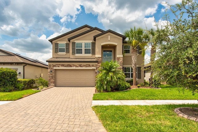11035 Sage Canyon Dr, Riverview, FL 33578 - view of front of property with stucco siding, an attached garage, decorative driveway, a front lawn, and stone siding