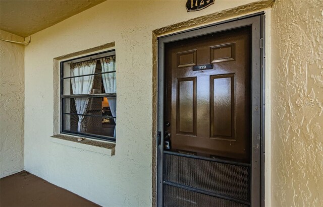 1729 Seascape Cir Unit 102, Tarpon Springs, FL 34689 - doorway to property featuring stucco siding