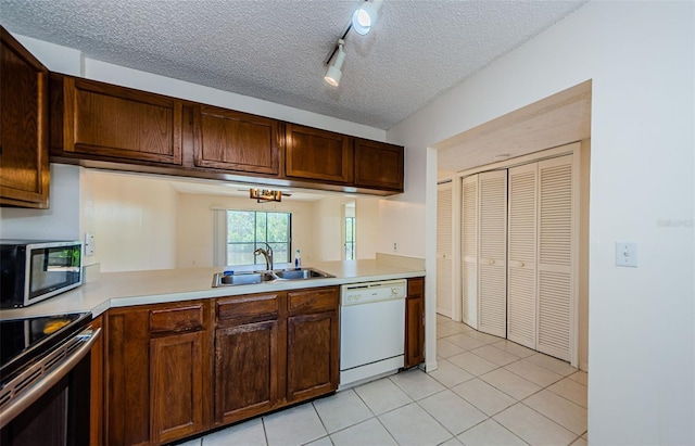 1729 Seascape Cir Unit 102, Tarpon Springs, FL 34689 - kitchen with appliances with stainless steel finishes, light countertops, track lighting, light tile patterned floors, and a textured ceiling