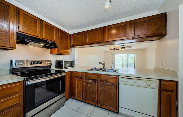 1729 Seascape Cir Unit 102, Tarpon Springs, FL 34689 - kitchen with stainless steel appliances, under cabinet range hood, light countertops, and a textured ceiling
