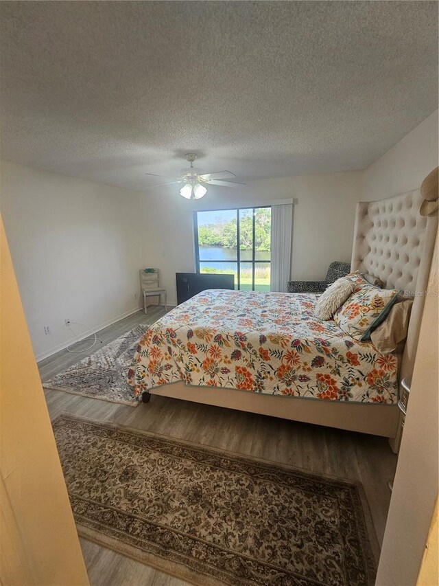 1729 Seascape Cir Unit 102, Tarpon Springs, FL 34689 - bedroom featuring wood finished floors, a ceiling fan, and a textured ceiling