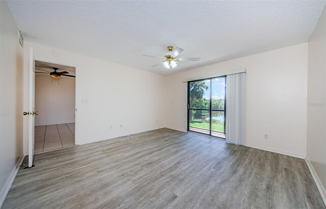 1729 Seascape Cir Unit 102, Tarpon Springs, FL 34689 - spare room with wood finished floors, a ceiling fan, and a textured ceiling