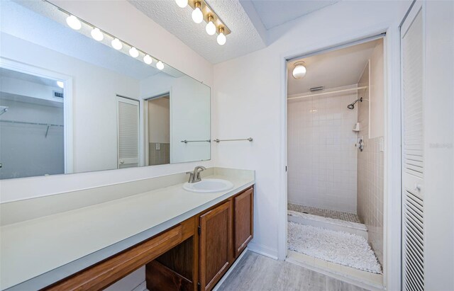 1729 Seascape Cir Unit 102, Tarpon Springs, FL 34689 - full bath featuring vanity, a tile shower, and wood finished floors