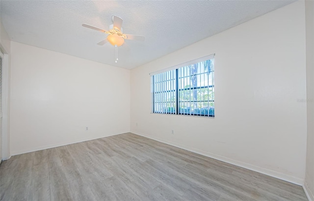 1729 Seascape Cir Unit 102, Tarpon Springs, FL 34689 - spare room with wood finished floors, a ceiling fan, and a textured ceiling