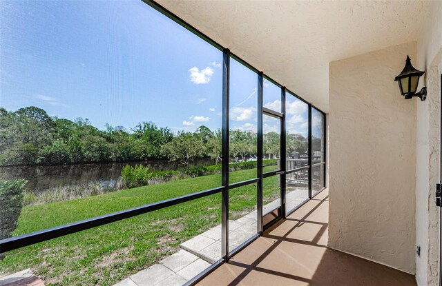 1729 Seascape Cir Unit 102, Tarpon Springs, FL 34689 - unfurnished sunroom with a water view, healthy amount of natural light, and view of wooded area