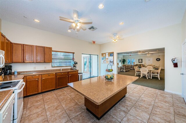 1729 Seascape Cir Unit 102, Tarpon Springs, FL 34689 - kitchen with white appliances, brown cabinetry, a ceiling fan, light tile patterned floors, and recessed lighting