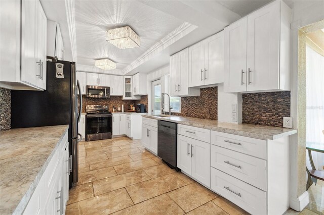 10730 52nd Ave N, Saint Petersburg, FL 33708 - kitchen featuring appliances with stainless steel finishes, white cabinetry, decorative backsplash, and light countertops