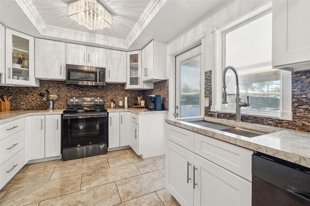 10730 52nd Ave N, Saint Petersburg, FL 33708 - kitchen featuring appliances with stainless steel finishes, a raised ceiling, tasteful backsplash, and crown molding