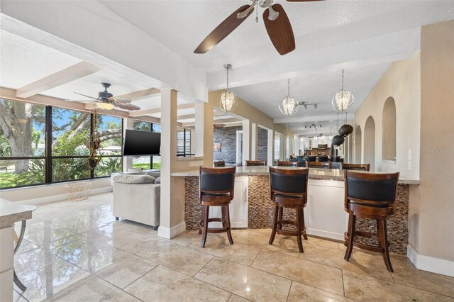 10730 52nd Ave N, Saint Petersburg, FL 33708 - kitchen featuring open floor plan, ceiling fan, a chandelier, a breakfast bar area, and pendant lighting