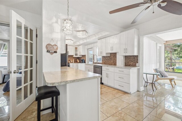 10730 52nd Ave N, Saint Petersburg, FL 33708 - kitchen featuring stainless steel dishwasher, backsplash, plenty of natural light, and light countertops