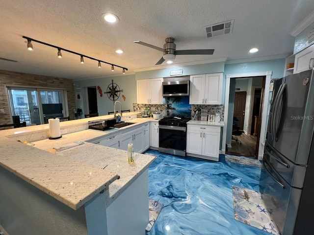 6531 Seaview Blvd, Hudson, FL 34667 - kitchen featuring stove, freestanding refrigerator, stainless steel microwave, a peninsula, and white cabinetry