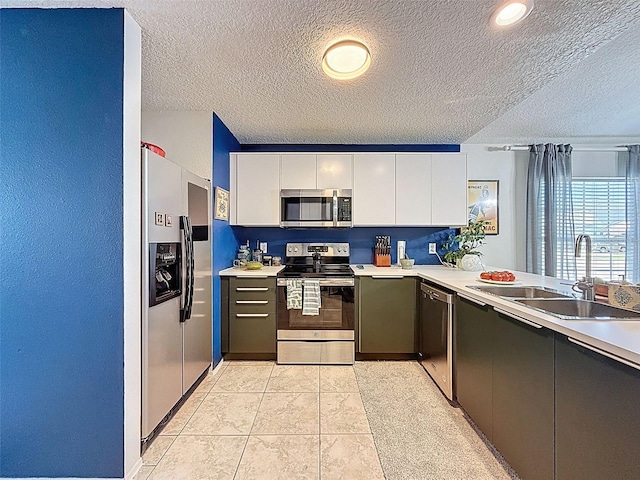 kitchen featuring stainless steel appliances, white cabinetry, a textured ceiling, light countertops, and modern cabinets
