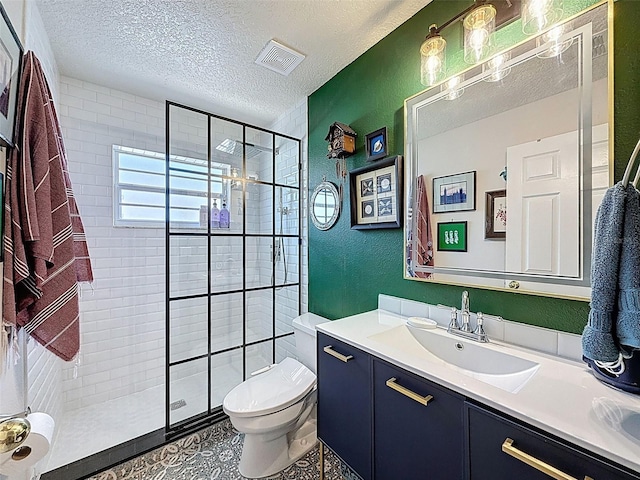 full bath featuring vanity, a textured ceiling, a tile shower, and a textured wall