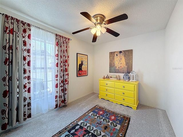 carpeted bedroom with a textured ceiling and ceiling fan