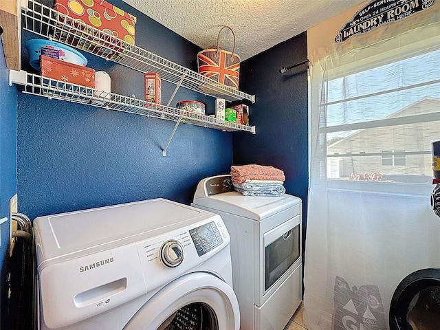 laundry room with separate washer and dryer, a textured wall, and a textured ceiling