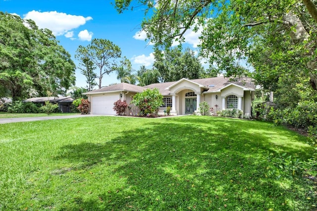 2454 Shadecrest Rd, Land O Lakes, FL 34639 - ranch-style house featuring a garage, driveway, a front yard, stucco siding, and french doors