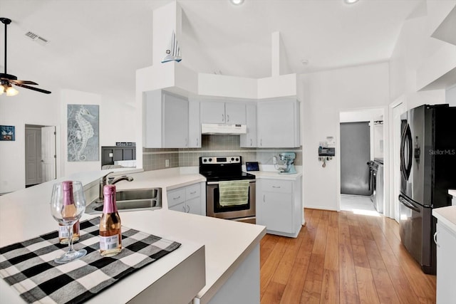 2454 Shadecrest Rd, Land O Lakes, FL 34639 - kitchen featuring freestanding refrigerator, stainless steel electric stove, under cabinet range hood, light countertops, and tasteful backsplash