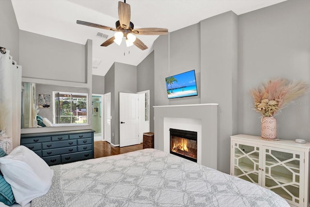 2454 Shadecrest Rd, Land O Lakes, FL 34639 - bedroom with high vaulted ceiling, a glass covered fireplace, wood finished floors, and a ceiling fan