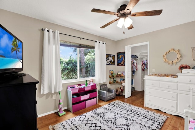 2454 Shadecrest Rd, Land O Lakes, FL 34639 - bedroom featuring wood finished floors, a walk in closet, a closet, and ceiling fan