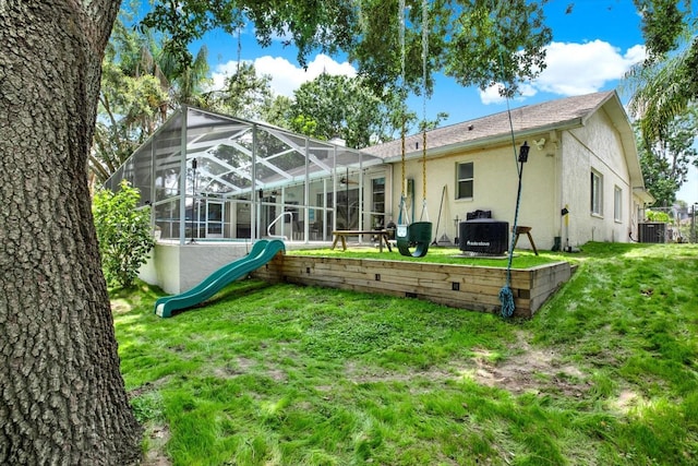 2454 Shadecrest Rd, Land O Lakes, FL 34639 - rear view of house featuring stucco siding, a lawn, and glass enclosure