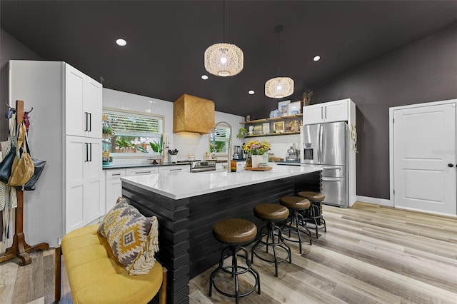 1313 W Carissa Ct, Tampa, FL 33604 - kitchen with appliances with stainless steel finishes, open shelves, vaulted ceiling, light wood-style floors, and decorative light fixtures