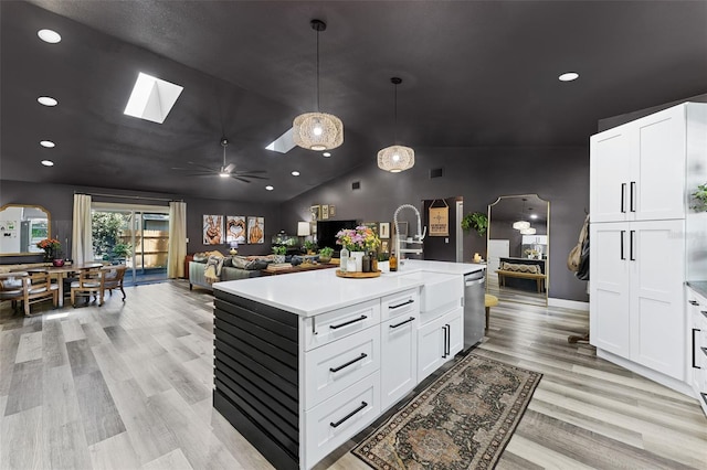 1313 W Carissa Ct, Tampa, FL 33604 - kitchen featuring dishwasher, light wood-style floors, light countertops, lofted ceiling, and a skylight