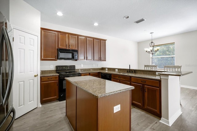11132 Creek Haven Dr, Riverview, FL 33569 - kitchen featuring black appliances, a peninsula, a chandelier, light wood-type flooring, and recessed lighting