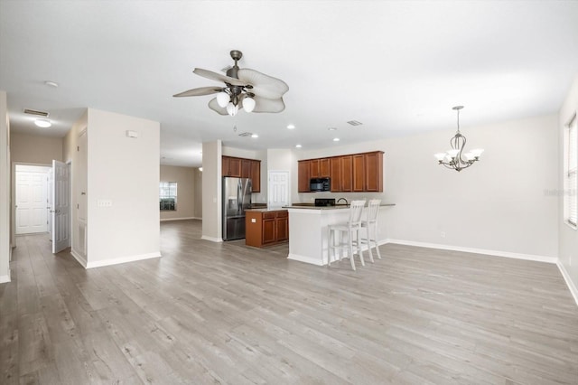 11132 Creek Haven Dr, Riverview, FL 33569 - kitchen with stainless steel refrigerator with ice dispenser, open floor plan, a breakfast bar area, light wood-type flooring, and recessed lighting