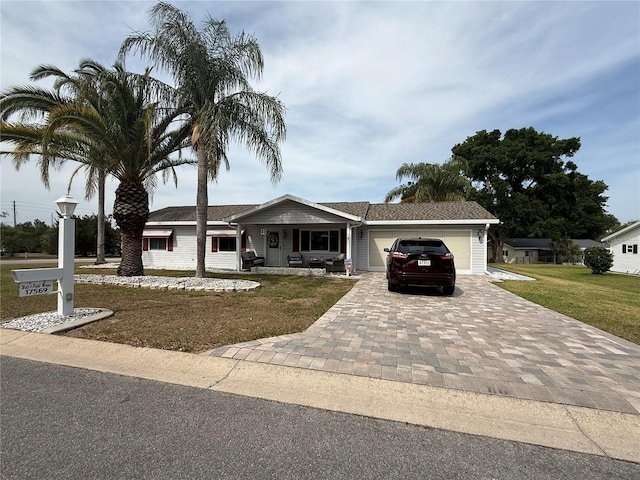 17569 SE 107th Ct, Summerfield, FL 34491 - view of front of home featuring an attached garage, decorative driveway, a front yard, and a porch