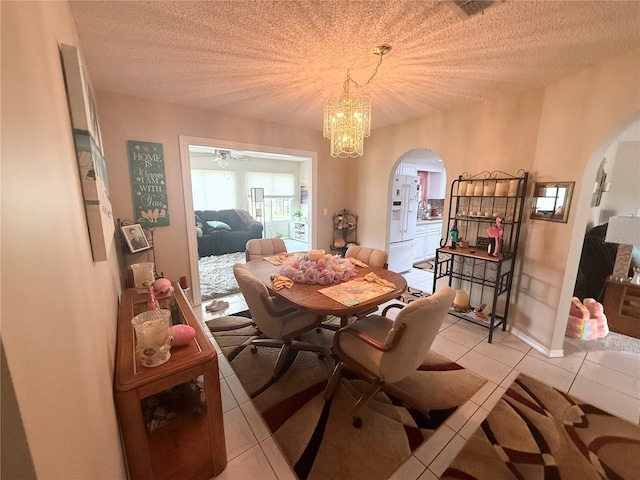 17569 SE 107th Ct, Summerfield, FL 34491 - dining space featuring arched walkways, light tile patterned flooring, a chandelier, a textured ceiling, and a ceiling fan