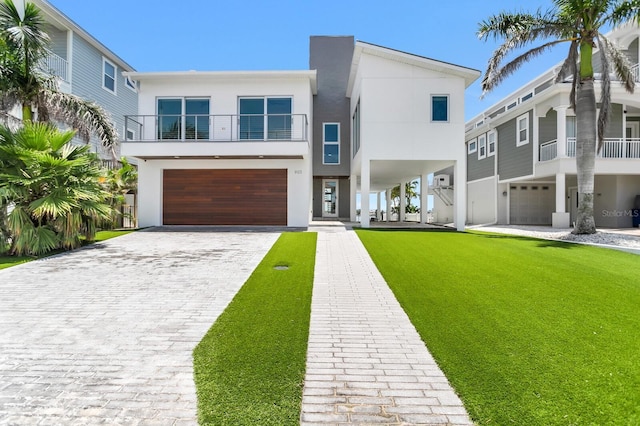 905 Bay Point Dr, Madeira Beach, FL 33708 - view of front of home featuring stucco siding, a garage, driveway, and a front yard