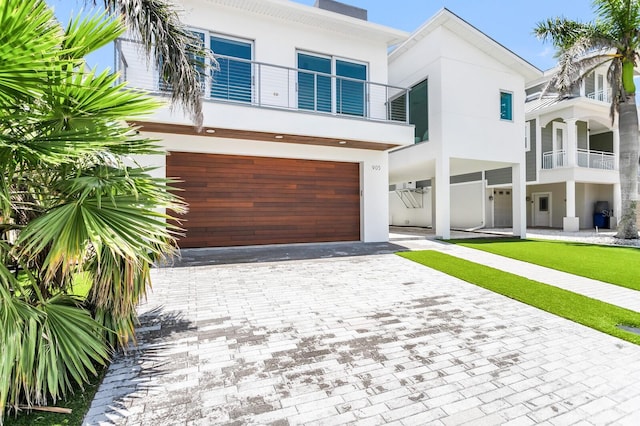 905 Bay Point Dr, Madeira Beach, FL 33708 - view of front facade with stucco siding, an attached garage, and decorative driveway