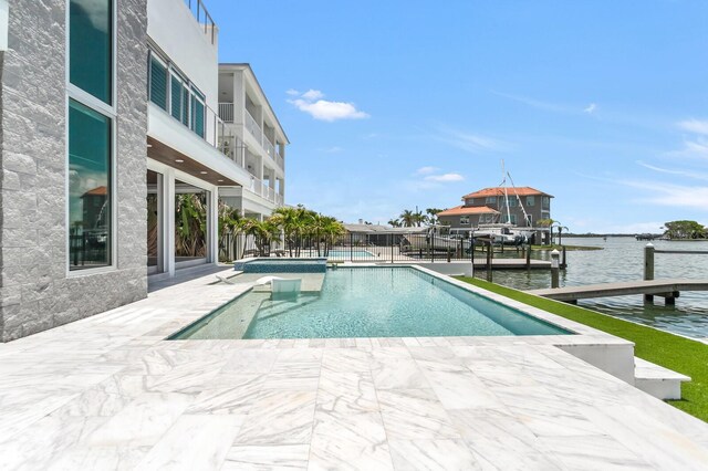 905 Bay Point Dr, Madeira Beach, FL 33708 - view of swimming pool featuring a patio, a dock, a water view, boat lift, and a pool with connected hot tub