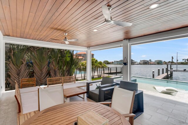 905 Bay Point Dr, Madeira Beach, FL 33708 - view of patio / terrace with a boat dock, boat lift, ceiling fan, a water view, and outdoor dining area