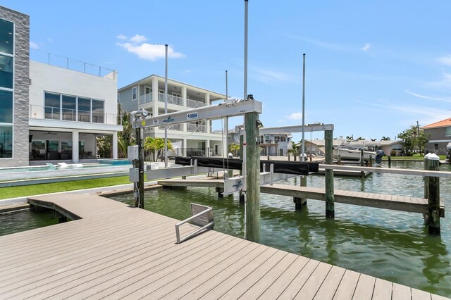 905 Bay Point Dr, Madeira Beach, FL 33708 - dock with a water view, boat lift, and a pool