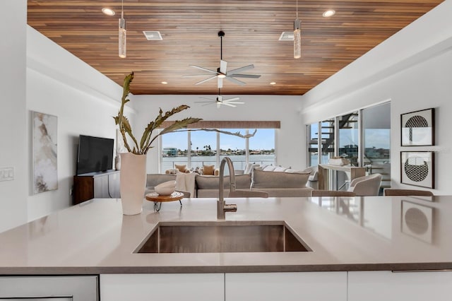 905 Bay Point Dr, Madeira Beach, FL 33708 - kitchen featuring open floor plan, wooden ceiling, a ceiling fan, and white cabinetry