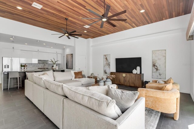 905 Bay Point Dr, Madeira Beach, FL 33708 - living area with ceiling fan, dark tile patterned flooring, wooden ceiling, and recessed lighting