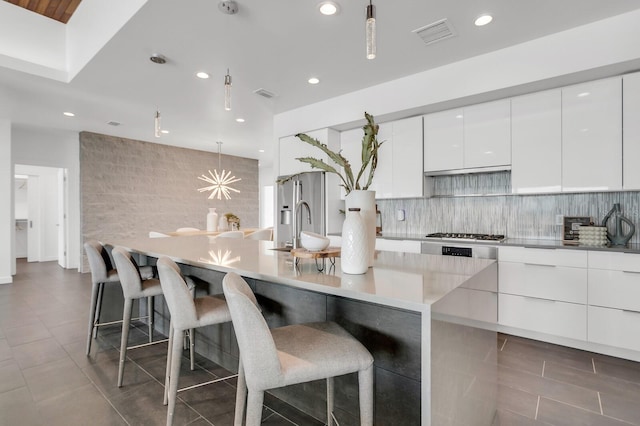 905 Bay Point Dr, Madeira Beach, FL 33708 - kitchen featuring modern cabinets, white cabinets, recessed lighting, gas stovetop, and pendant lighting