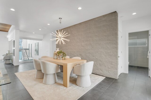 905 Bay Point Dr, Madeira Beach, FL 33708 - dining area with tile walls, recessed lighting, a chandelier, and dark tile patterned floors