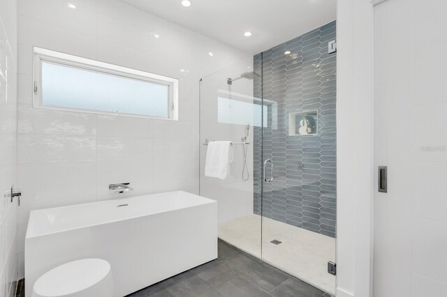 905 Bay Point Dr, Madeira Beach, FL 33708 - bathroom with a soaking tub, a stall shower, recessed lighting, tile walls, and tile patterned floors