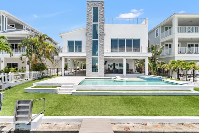 905 Bay Point Dr, Madeira Beach, FL 33708 - rear view of property with a patio, a pool with connected hot tub, stucco siding, and a balcony