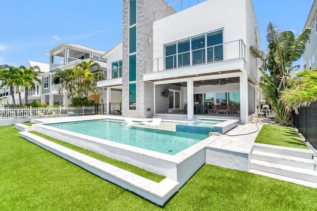 905 Bay Point Dr, Madeira Beach, FL 33708 - rear view of property with a patio, stucco siding, a balcony, and a pool with connected hot tub