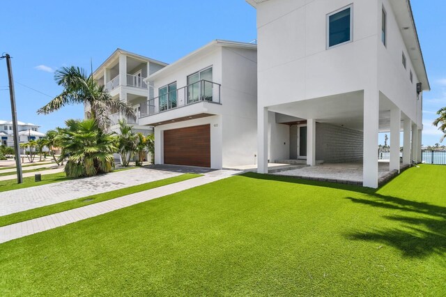 905 Bay Point Dr, Madeira Beach, FL 33708 - contemporary house with stucco siding, a garage, a front yard, and driveway